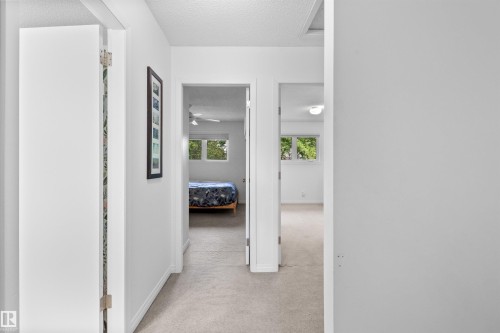 Hallway with light-colored carpet flooring, white walls, and white trim - 10940 123 Street, Edmonton, AB 