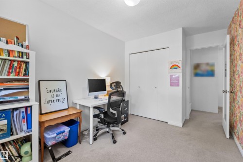 Carpeted room with a built-in closet featuring bi-fold doors - 10940 123 Street, Edmonton, AB 