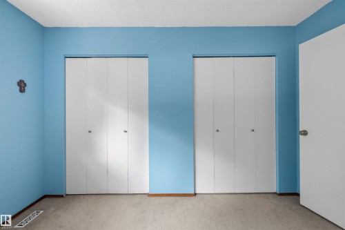 Dual white bi-fold closet doors with polished chrome hardware - 10940 123 Street, Edmonton, AB 
