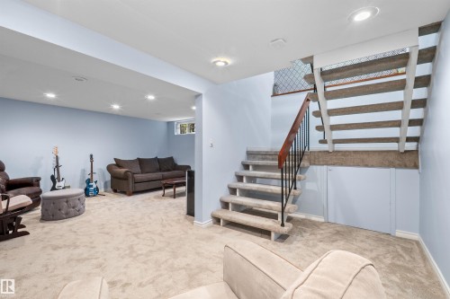 Finished lower level featuring light blue walls and neutral carpeting - 10940 123 Street, Edmonton, AB 
