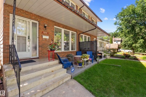 Brick exterior with a covered porch featuring concrete steps and a wrought iron railing - 10940 123 Street, Edmonton, AB 