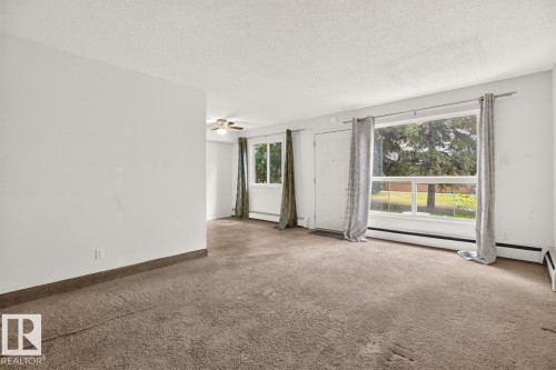Spacious interior featuring neutral carpeting and white walls - 106 237 Woodvale Road W, Edmonton, AB 