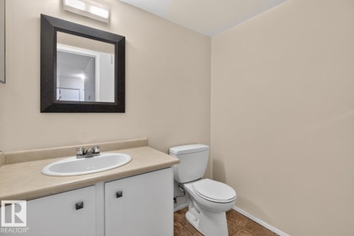 Bathroom featuring a white vanity with a tan countertop, an oval undermount sink, and a chrome faucet - 106 237 Woodvale Road W, Edmonton, AB 