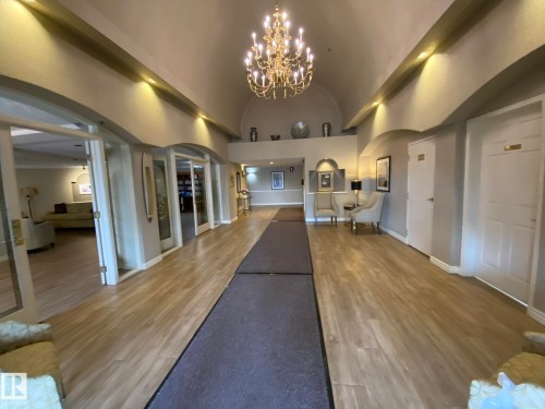 Spacious foyer with arched doorways, recessed lighting, and a prominent chandelier - 102 10903 21 Avenue, Edmonton, AB - Indoor Photo Showing Other Room