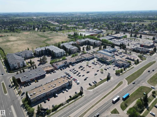 Commercial properties situated along a multi-lane thoroughfare, featuring multiple parking lots and a diverse selection of retail buildings - 102 10903 21 Avenue, Edmonton, AB -  With View
