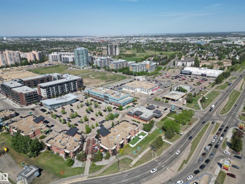 Urban landscape featuring commercial and residential buildings, expansive paved parking areas, and multi-lane roadways - 102 10903 21 Avenue, Edmonton, AB - Outdoor With View