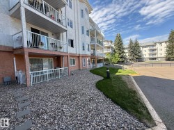 Multi-story building featuring white stucco siding and private balconies with white railings - 