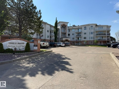 Multi-story residential building with light-colored siding and a prominent entryway - 102 10903 21 Avenue, Edmonton, AB - Outdoor
