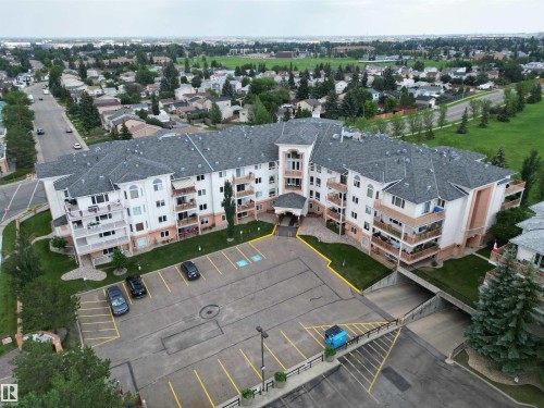 Multi-story residential building featuring balconies, a paved parking area, and an underground parking entrance - 102 10903 21 Avenue, Edmonton, AB - Outdoor With View