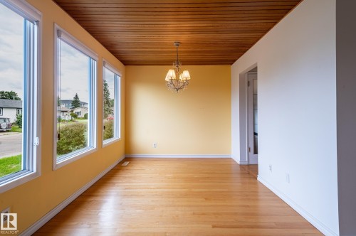 Room featuring wood-finish flooring, a wood-paneled ceiling, and a multi-pane window array - 11415 142 Avenue, Edmonton, AB 