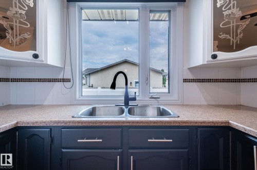 Dual basin stainless steel sink with a matte black gooseneck faucet - 11415 142 Avenue, Edmonton, AB 