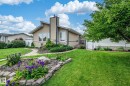 Stucco exterior with an asymmetric roofline and prominent chimney - 11415 142 Avenue Nw, Edmonton, AB 