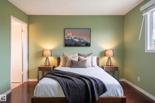 Interior room featuring wood-finish flooring, light green walls, a white ceiling, and a white-framed window - 11415 142 Avenue, Edmonton, AB 