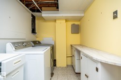Dedicated laundry area featuring a tile floor, white built-in cabinetry, and an extended countertop space - 