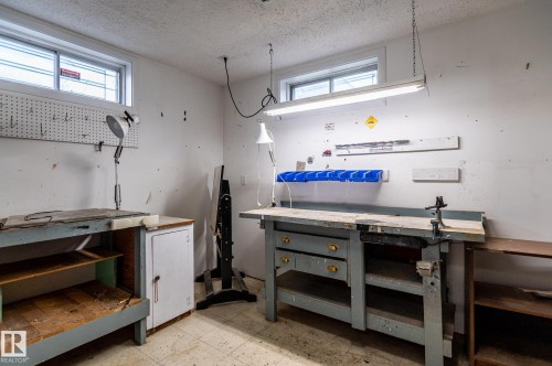 Utility room featuring two workspaces, white painted walls, and overhead fluorescent lighting - 11415 142 Avenue, Edmonton, AB 