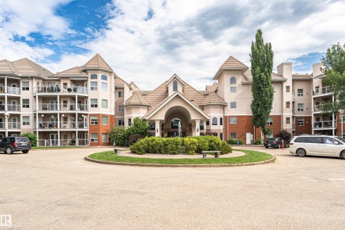 Multi-story residential complex featuring a central arched entrance, prominent turrets, and individual balconies - 130 9008 99 Avenue Nw, Edmonton, AB 