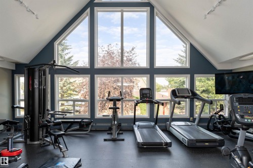Dedicated fitness space featuring a soaring vaulted ceiling with multiple large windows - 130 9008 99 Avenue Nw, Edmonton, AB 