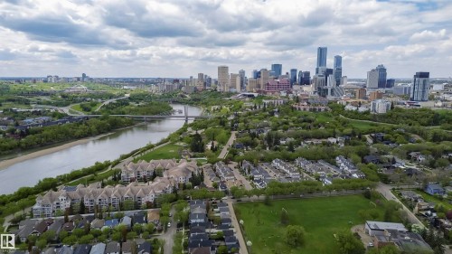 Aerial perspective showcasing a sprawling urban landscape with a prominent river, dense tree coverage, and a distant city skyline - 130 9008 99 Avenue Nw, Edmonton, AB 