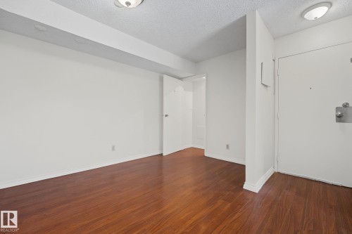 Main living area featuring wood-finish flooring and white baseboards - #6E 11608 28 Av Nw Nw, Edmonton, AB - Indoor Photo Showing Other Room