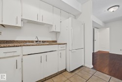 Kitchen featuring white cabinetry, a stainless steel sink, and a speckled countertop - 