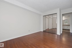 Room featuring wood-finish flooring, white baseboards, and neutral wall paint - 