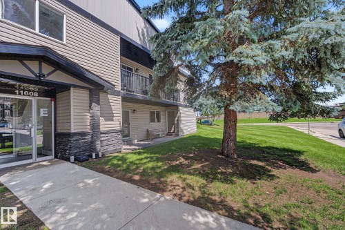 Contemporary multi-level building with tan horizontal siding and dark stone veneer accents - #6E 11608 28 Av Nw Nw, Edmonton, AB - Outdoor With Balcony