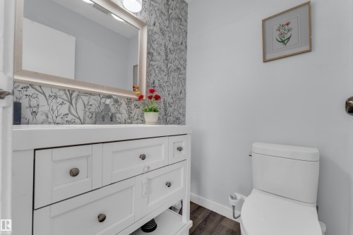 Vanity with white shaker-style cabinetry, a built-in sink, and a framed mirror with integrated lighting - 1316 35 Street, Edmonton, AB 
