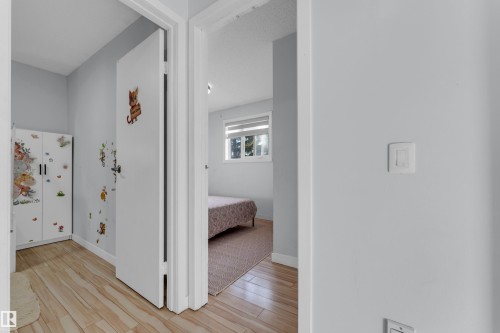 Hallway featuring wood-finish flooring and light gray painted walls - 1316 35 Street, Edmonton, AB 