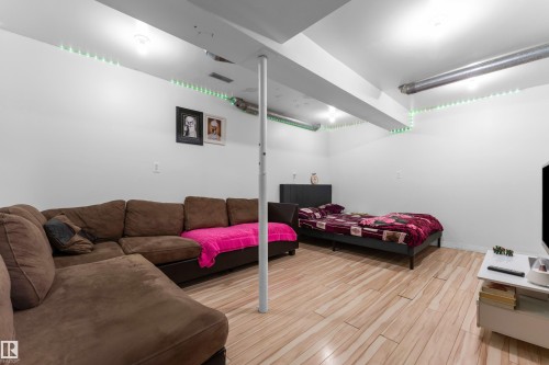 Finished room featuring light wood-finish flooring, white walls, exposed ceiling ductwork, and recessed lighting - 1316 35 Street, Edmonton, AB 