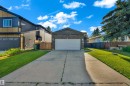 Single-story residence featuring a stone facade and an attached garage with a white door - 1316 35 Street, Edmonton, AB 