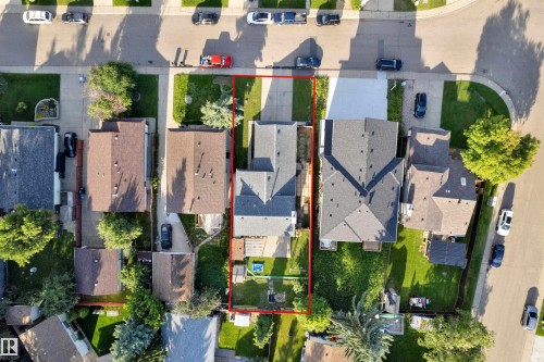 Aerial property view featuring a charcoal gray shingle roof, paved driveway, and established green lawns - 1316 35 Street, Edmonton, AB 