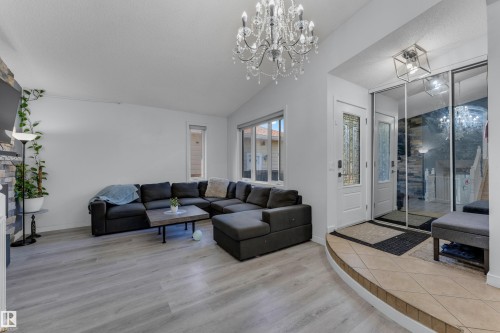 Living area featuring light wood-finish flooring and a stone-clad fireplace - 1316 35 Street, Edmonton, AB 