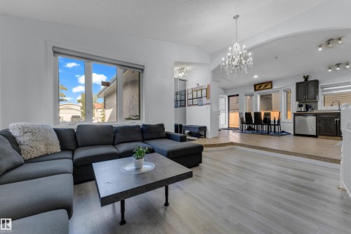 Spacious living area featuring light wood-finish flooring and large windows - 1316 35 Street, Edmonton, AB 