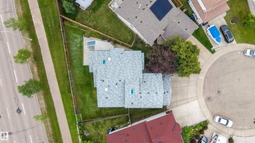 Aerial perspective showcasing a property with a light gray shingle roof, multiple skylights, and a green lawn - 15227 47 Street, Edmonton, AB 
