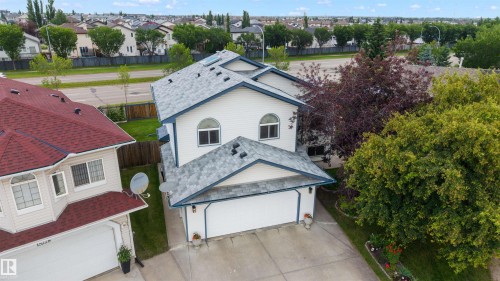 Two-story exterior featuring white siding and a multi-pitch gray shingle roof - 15227 47 Street, Edmonton, AB 