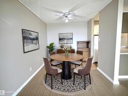 Dining area featuring wood-finish flooring, light grey walls, and a ceiling fan with integrated lighting - 