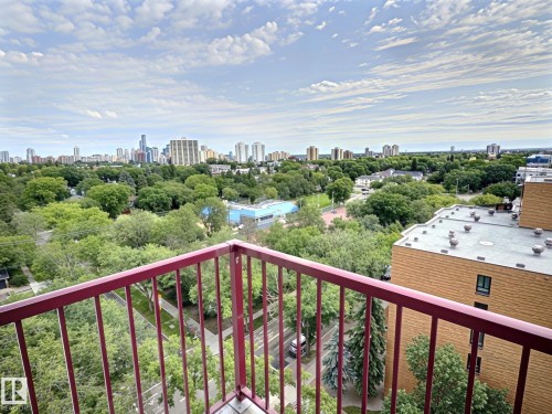 Expansive urban landscape featuring a cityscape backdrop, abundant mature trees, and a street below - 1105 11007 83 Avenue, Edmonton, AB 