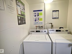 Dedicated laundry area featuring a top-load washer and dryer, wall-mounted instructions, and overhead lighting - 
