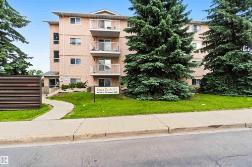 Multi-story residential building with light-colored exterior and multiple balconies - #304 4924 19 Av Nw, Edmonton, AB 