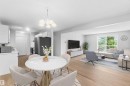 Open-concept living space featuring light wood-finish flooring, white walls, and a recessed kitchen - #304 4924 19 Av Nw, Edmonton, AB 