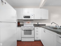 Bright kitchen featuring white cabinetry and appliances - 