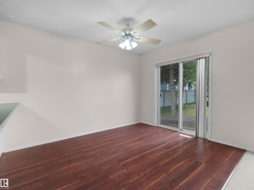 Spacious interior featuring wood-finish flooring, a ceiling fan with integrated lighting, and light-toned walls - 16106 131A Street, Edmonton, AB 