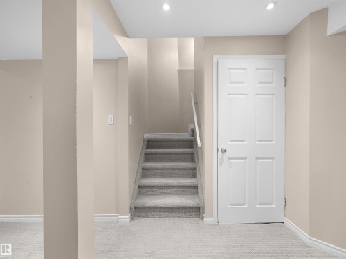 Carpeted staircase with white handrail and surrounding neutral-toned walls - 16106 131A Street, Edmonton, AB 