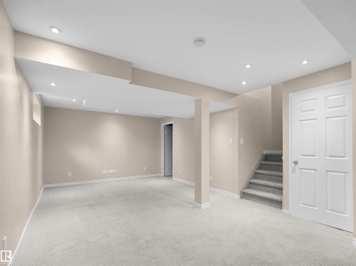 Carpeted lower-level room featuring recessed ceiling lighting, a staircase with carpeted treads, painted walls, and white trim - 16106 131A Street, Edmonton, AB 