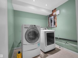 Dedicated laundry area with recessed lighting and neutral flooring - 