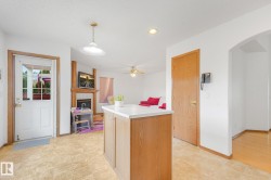 Kitchen island with a light-toned countertop, wood-finish cabinetry, and recessed lighting - 