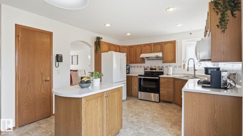 Bright kitchen with light wood-finish cabinetry and a white tiled backsplash - 1225 Kane Wynd, Edmonton, AB 