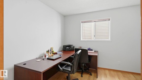 Light-filled room featuring a single window with blinds, light wood-finish flooring, and white painted walls - 1225 Kane Wynd, Edmonton, AB 