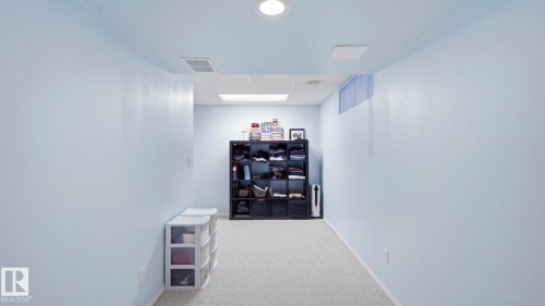 Carpeted interior space with light blue walls and recessed lighting - 1225 Kane Wynd, Edmonton, AB 