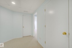 Recessed lighting fixture with a drop ceiling, light-colored carpeting, and white interior doors - 